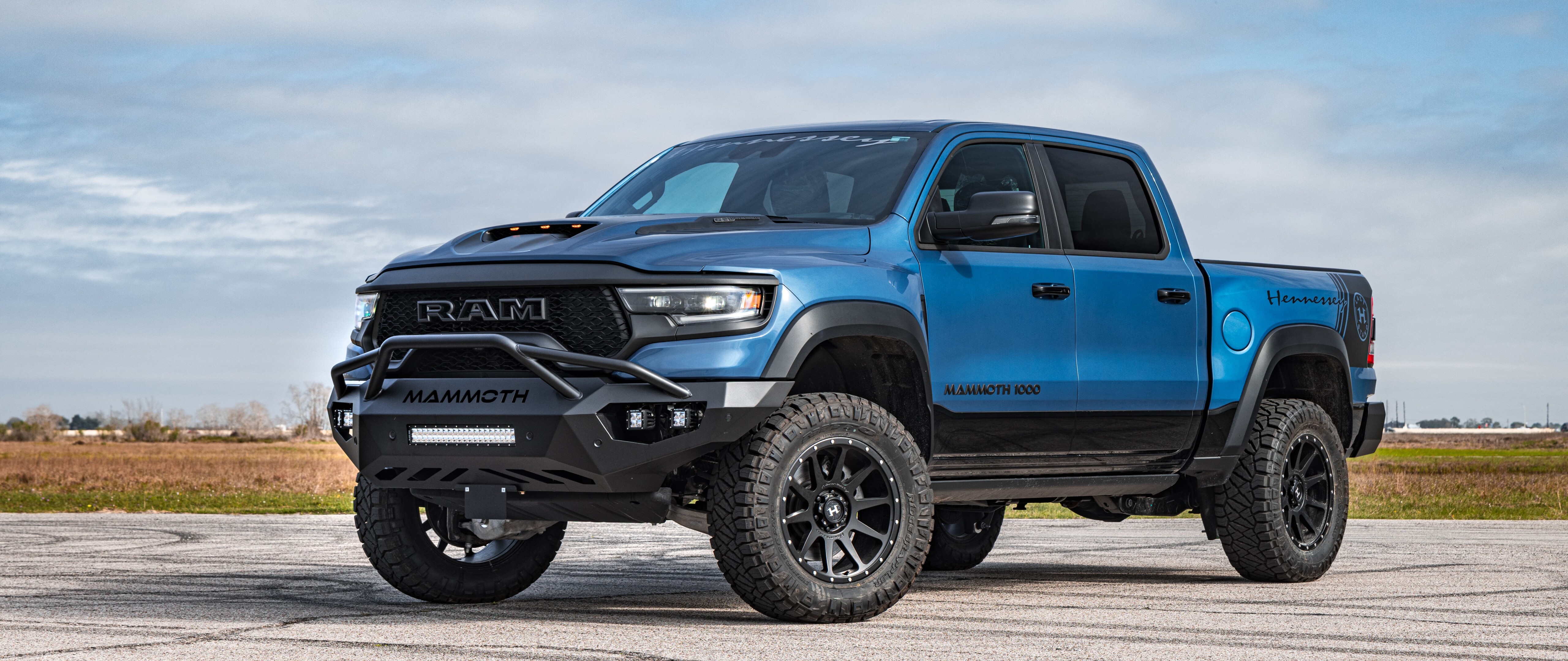Un imposant pick-up Dodge Ram Hennessey Mammoth 1000, doté d’une suspension surélevée, de modifications agressives pour la conduite tout-terrain et d’une carrosserie élargie.