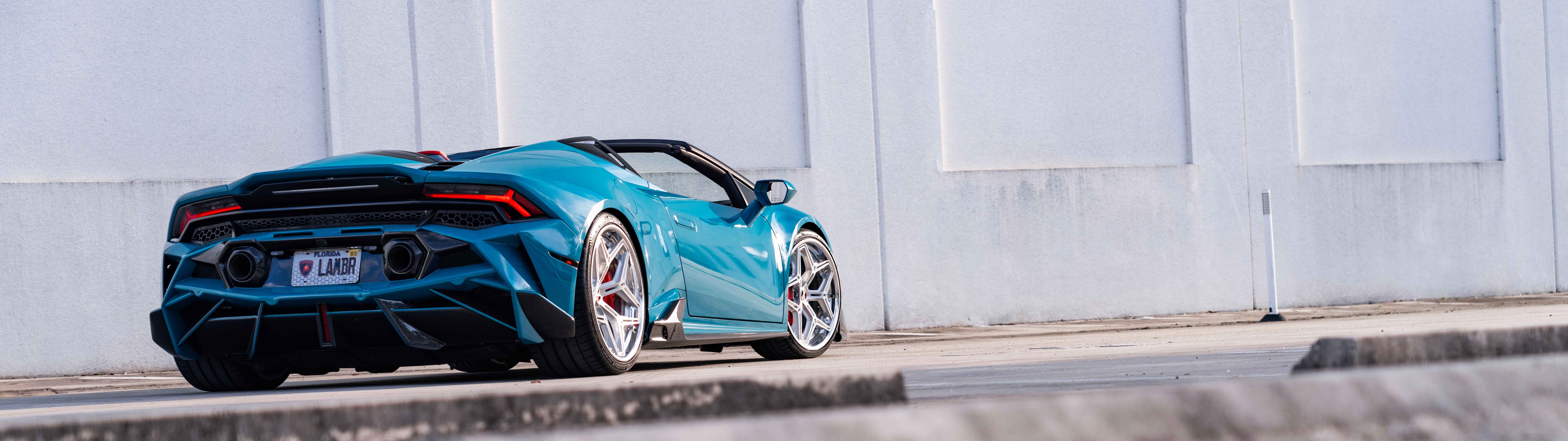 Une vue détaillée d’une Lamborghini Huracan Evo, mettant en valeur son emblématique carrosserie aérodynamique et sa silhouette élégante de voiture de sport.