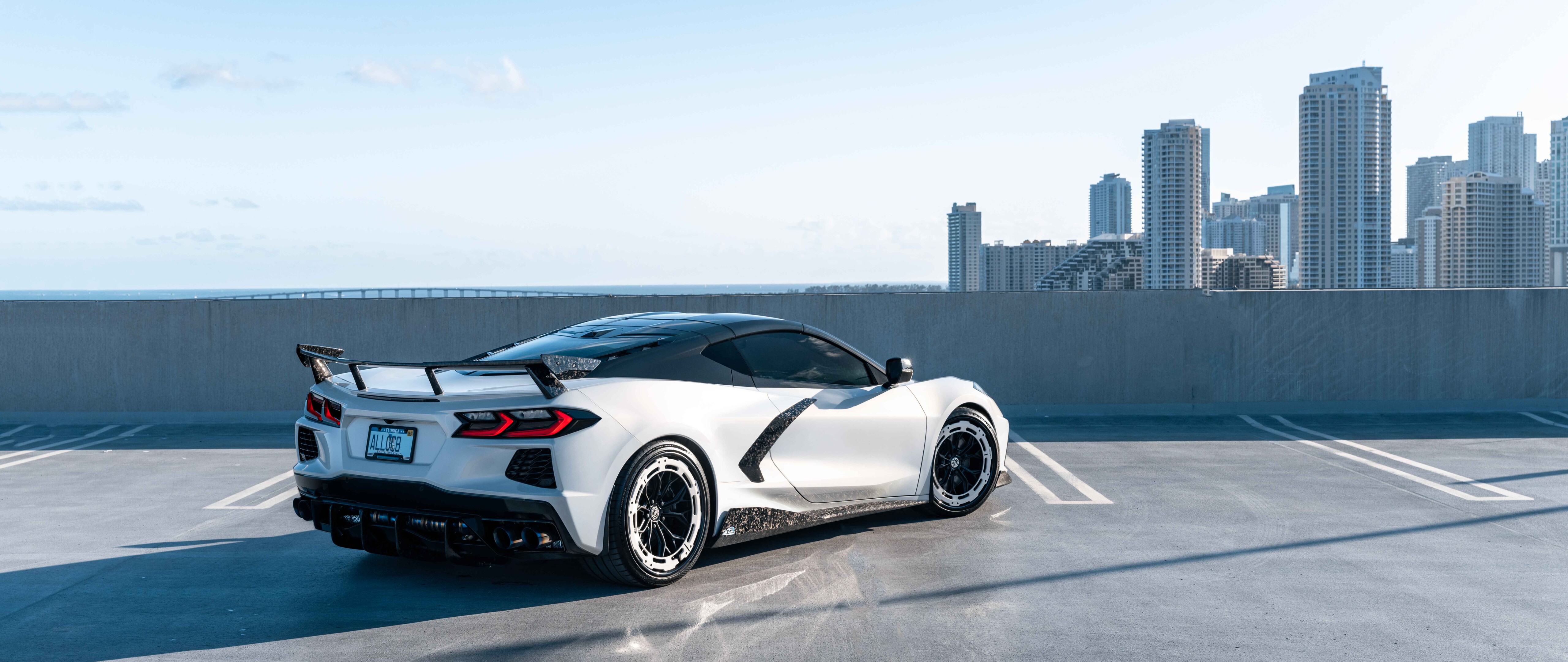Une vue détaillée d’une Chevrolet Corvette C8, une voiture de sport, mettant en valeur sa carrosserie aérodynamique et son design moderne.