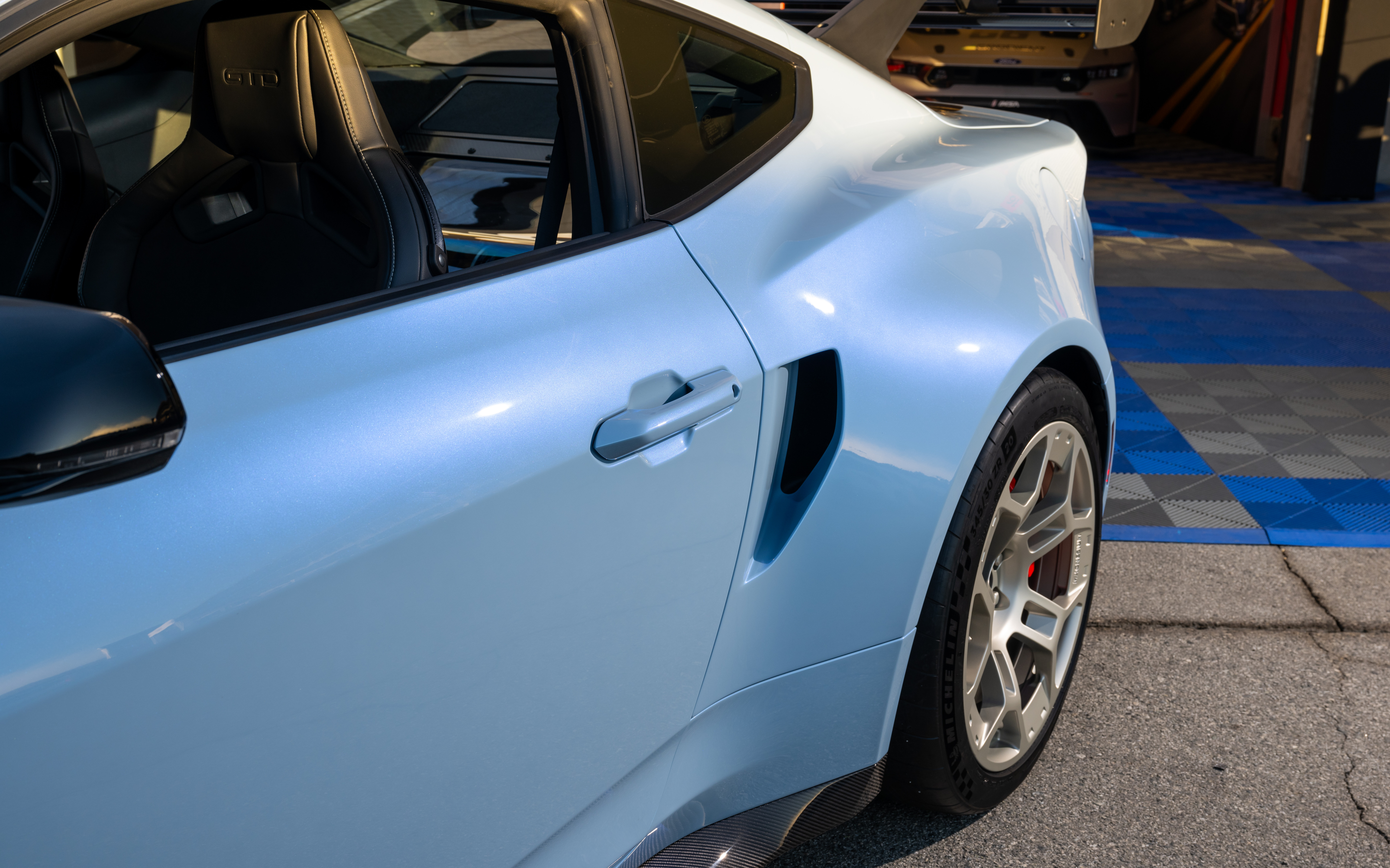 Une vue détaillée d’une Ford Mustang GTD, mettant en évidence son design aérodynamique audacieux et son kit carrosserie élargi.