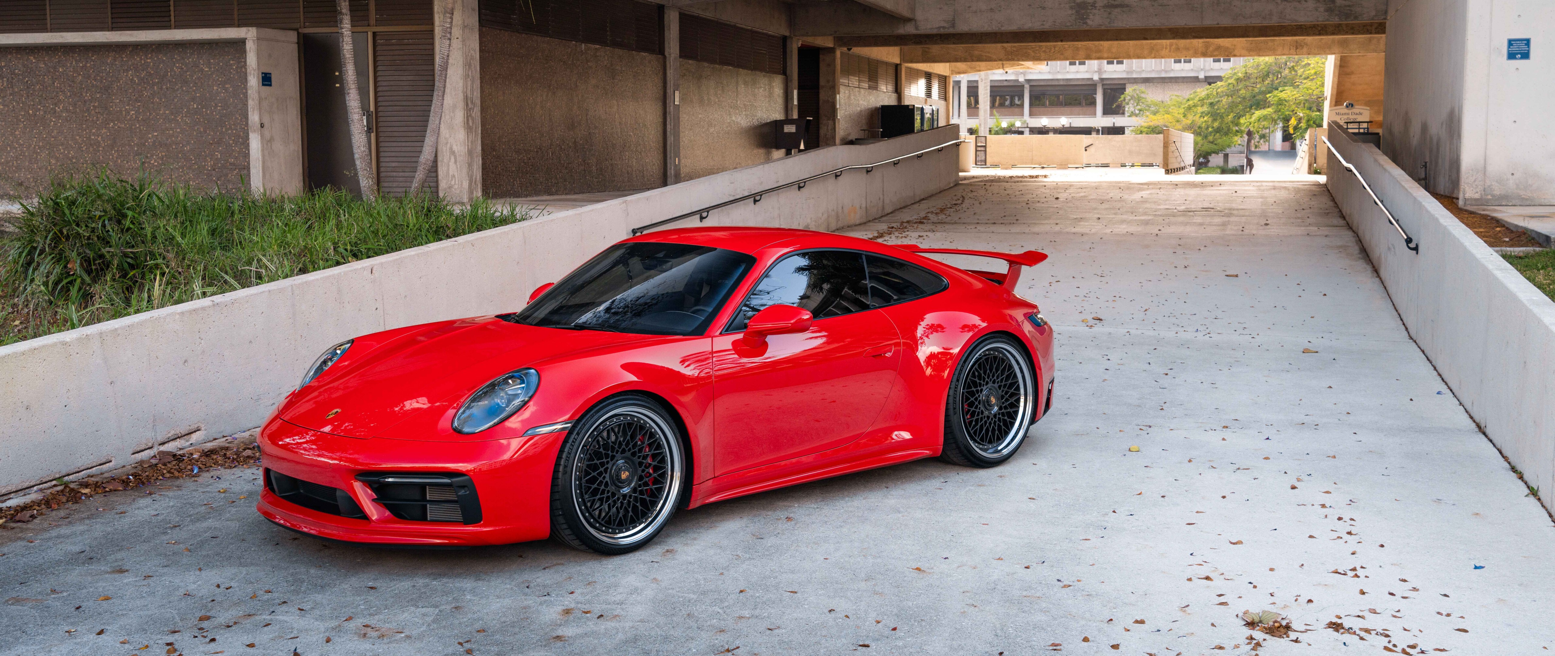 Une vue détaillée d’une Porsche 992 GTS, une voiture de sport dont on peut admirer la carrosserie aérodynamique et le design audacieux.