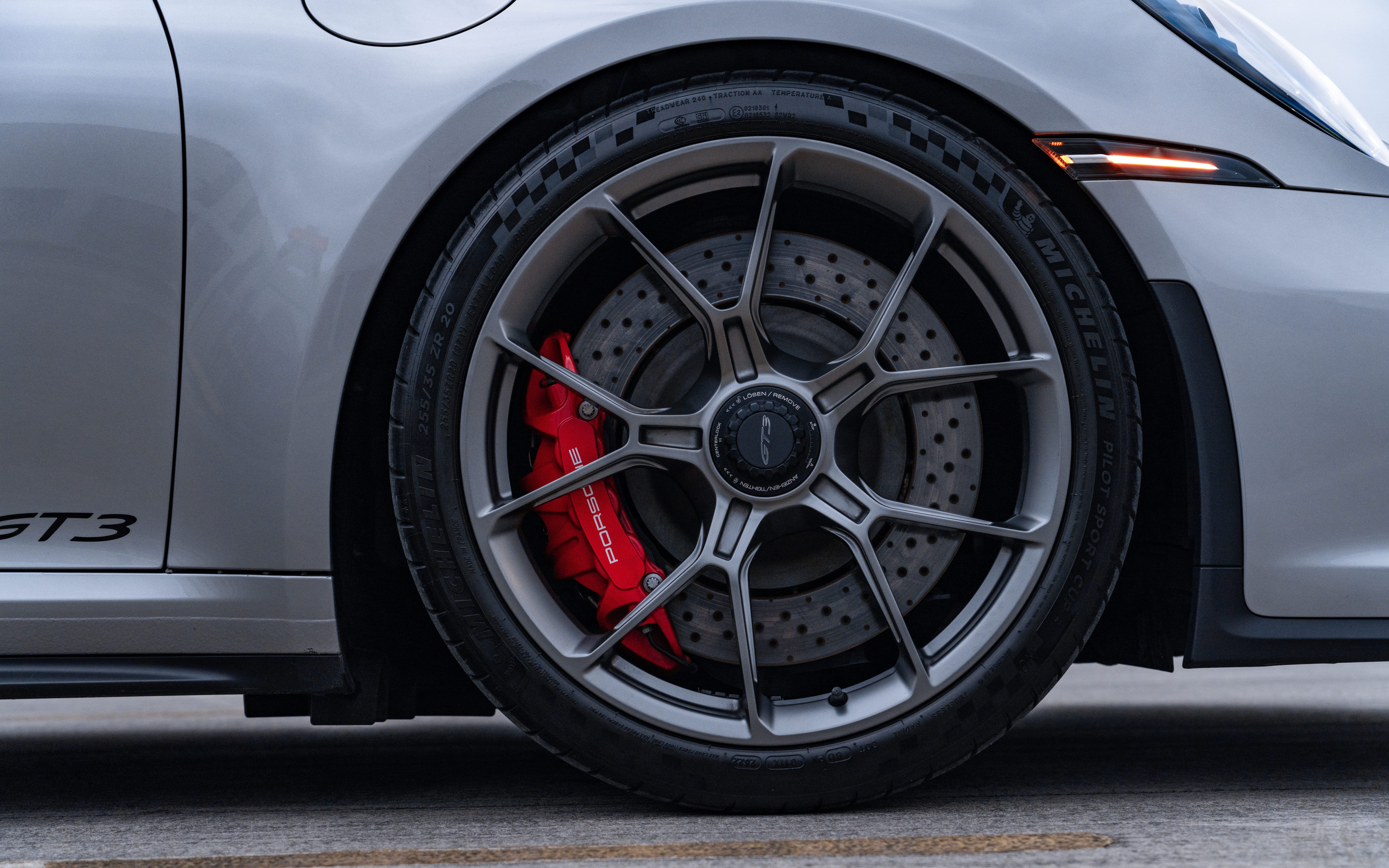 Une voiture de sport Porsche GT3 RS haute performance, dotée d’une carrosserie aérodynamique et d’un aileron arrière caractéristique.