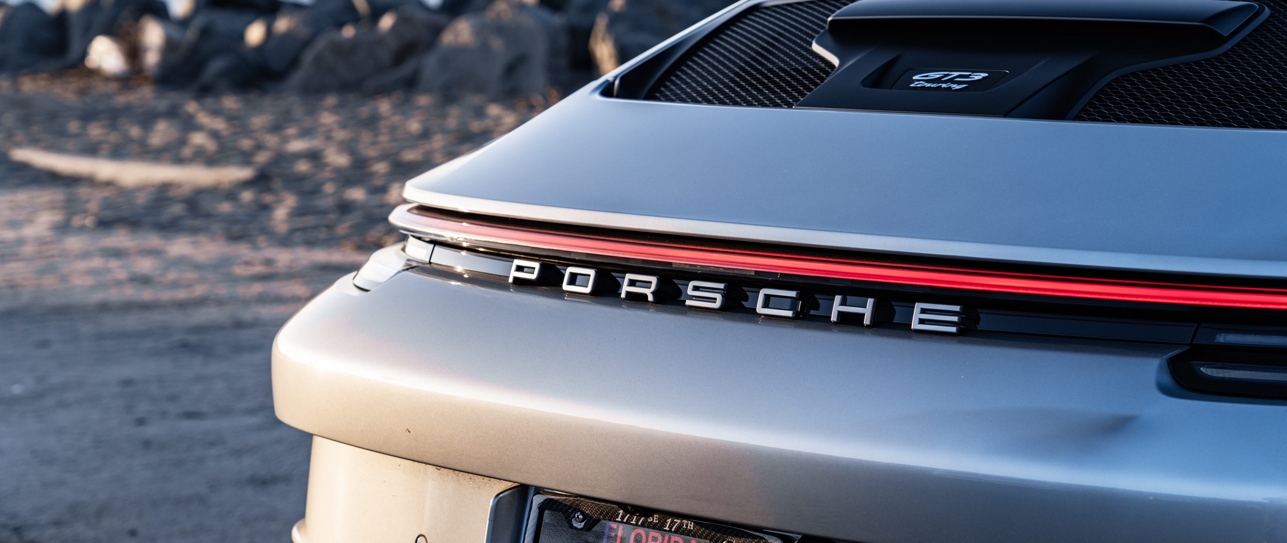 Une voiture de sport Porsche GT3 RS haute performance, dotée d’une carrosserie aérodynamique au design audacieux et d’une silhouette élégante, typique des voitures de course.