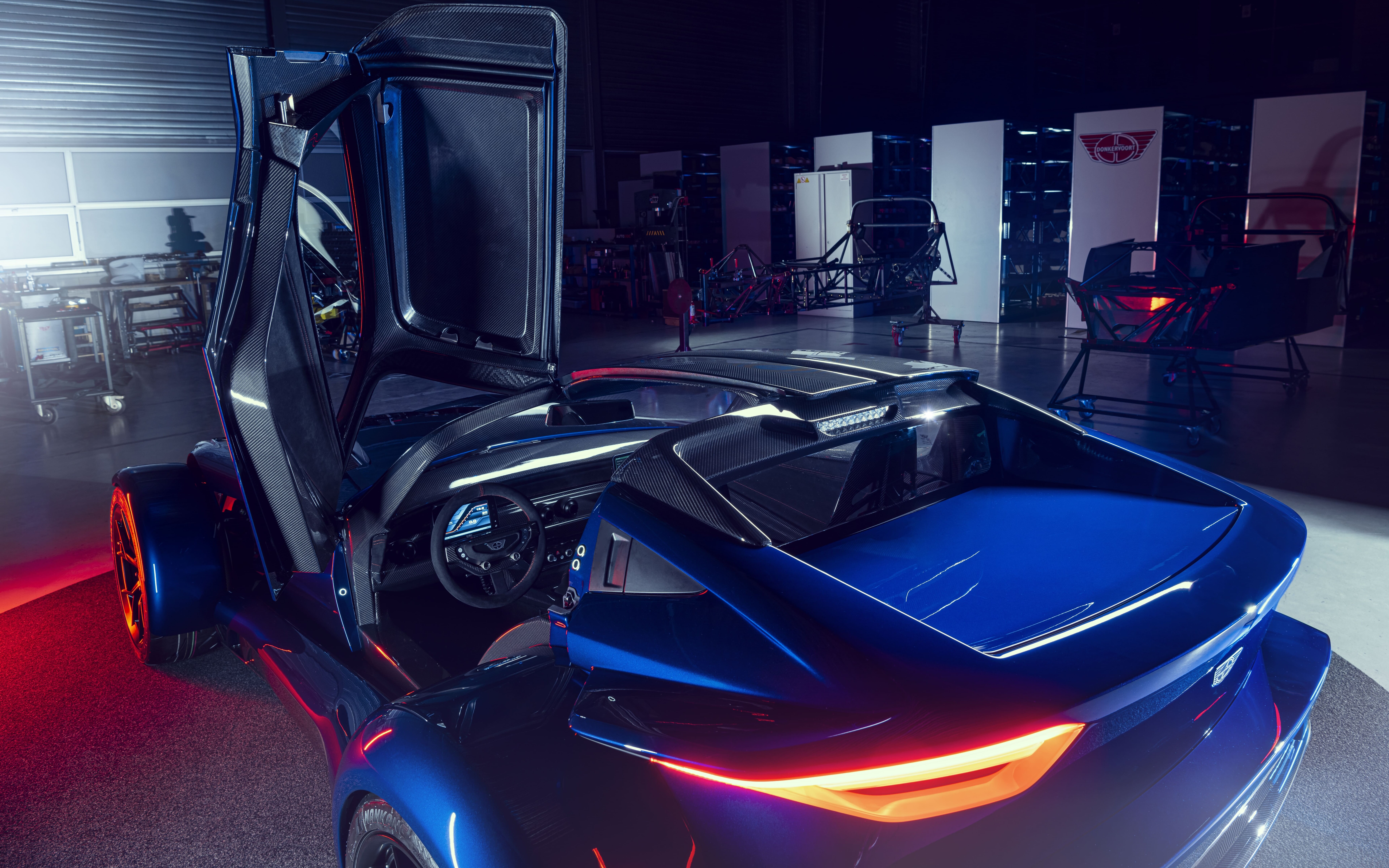 Une voiture de sport élégante, de couleur argent métallique, qui reflète la lumière douce d’un studio sur un fond sombre.